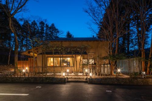 a house lit up at night with lights at 雅 仙石原 温泉旅館 Miyabi Sengokuhara Onsen Ryokan in Hakone