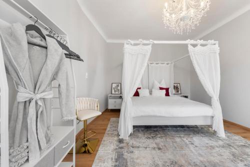 a bedroom with a canopy bed and a chandelier at Liebelei Miesbach Boutique Apartment - 2 Min zum Bahnhof, eigener Parkplatz in Miesbach