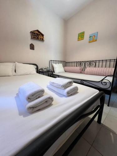 two beds in a room with towels on them at Family house in Skála Foúrkas