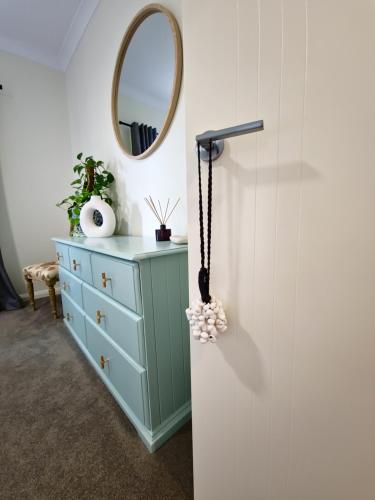a dressing room with a blue dresser and a mirror at Piper Apartment in Bathurst