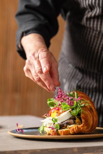 a person is preparing a food dish on a plate at Tsavta in Mashabbe Sade