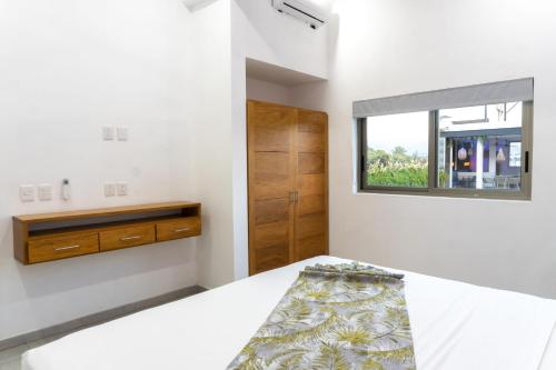 a bedroom with a bed and a window at Hotel y Departamentos Sofia in Rincon de Guayabitos