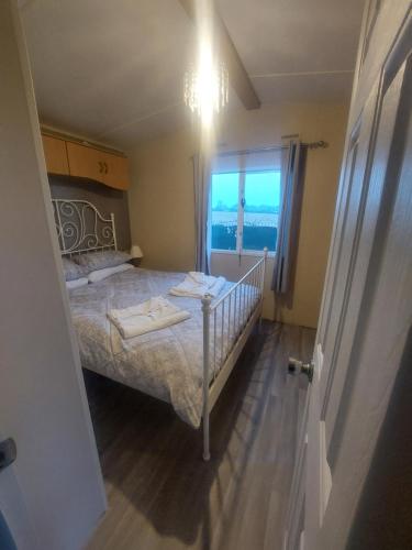 a bedroom with a bed with a view of the ocean at Cozy Caravans in Ramsgate in Ramsgate