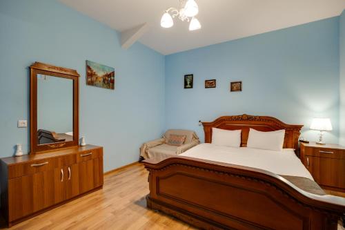 a bedroom with a bed and a dresser and a mirror at Rustaveli Two Bedroom Apartment with 5 Star Location in Tbilisi City