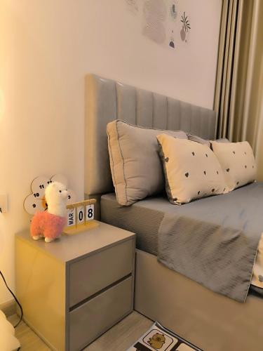 a small bedroom with a bed with a nightstand with a alarm clock at Vinhomes Smartcity- Căn hộ dịch vụ nguyên căn in Phú Thú