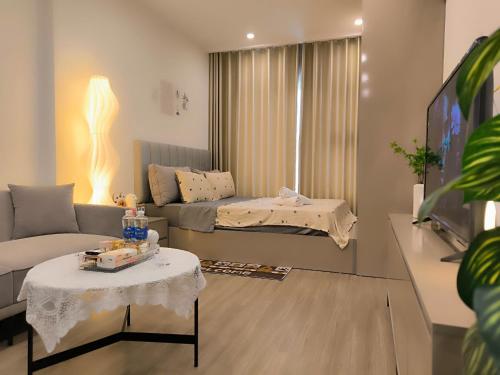 a living room with a couch and a table at Vinhomes Smartcity- Căn hộ dịch vụ nguyên căn in Phú Thú