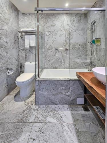 a bathroom with a tub and a toilet and a sink at CHECK inn Yilan LuoDong in Luodong