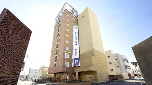 a building with a sign on the side of it at Toyoko Inn Kiryu eki Minami guchi in Kiryu