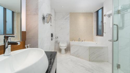 a white bathroom with a tub and a toilet at Holiday Inn Nanjing Aqua City by IHG in Nanjing
