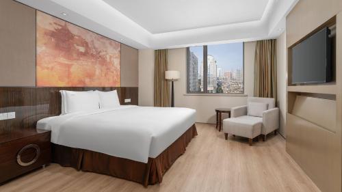 a hotel room with a large bed and a tv at Holiday Inn Nanjing Aqua City by IHG in Nanjing