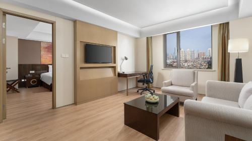 a living room with a couch and a room with a tv at Holiday Inn Nanjing Aqua City by IHG in Nanjing