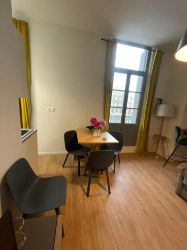 un salon avec une table et des chaises et une fenêtre dans l'établissement Emplacement rare élégant appartement avec balcon sur le Canal Royal, à Sète