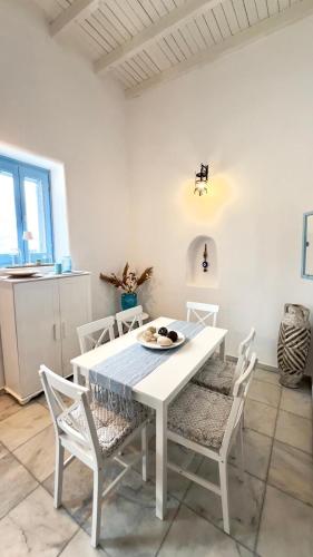 a white dining room with a white table and chairs at ''TSI TSI' traditional home & private Pool' in Kalithies