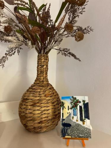 a wicker vase sitting on a table with a picture at ''TSI TSI' traditional home & private Pool' in Kalithies