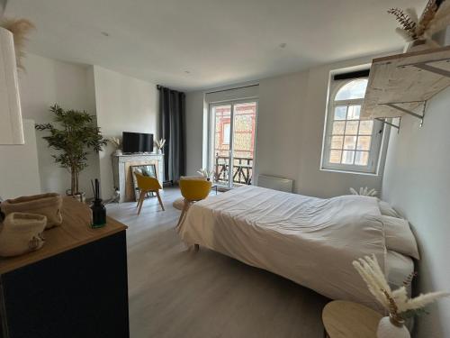 une chambre avec un lit, une table et une fenêtre dans l'établissement La danse des vagues, vue mer, à Fécamp