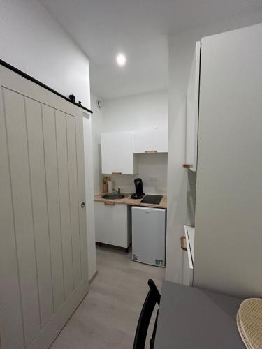 une cuisine avec des armoires blanches et un comptoir dans l'établissement La danse des vagues, vue mer, à Fécamp