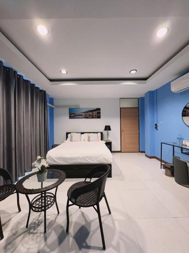 a bedroom with a bed and a table and chairs at Noc House in Bang Khlo
