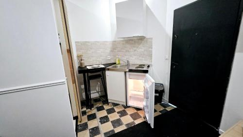 une petite cuisine avec un évier et une cuisinière dans l'établissement Studio Le Petit Valenciennois, à Valenciennes