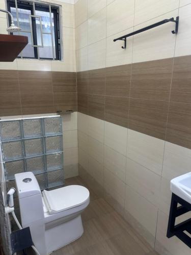 a bathroom with a toilet and a sink at Blue wave loft master bedroom in Dar es Salaam