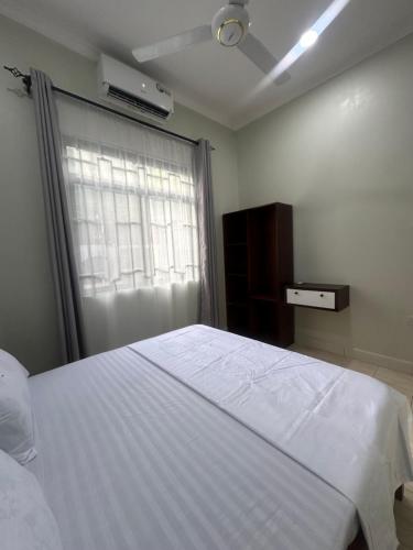 a bedroom with a white bed and a window at Blue wave loft master bedroom in Dar es Salaam