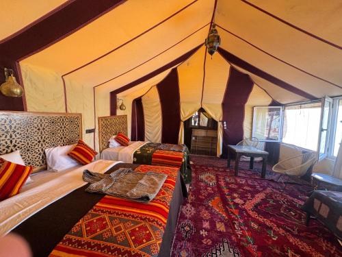 een slaapkamer met 2 bedden in een tent bij Dream luxury camp in Merzouga