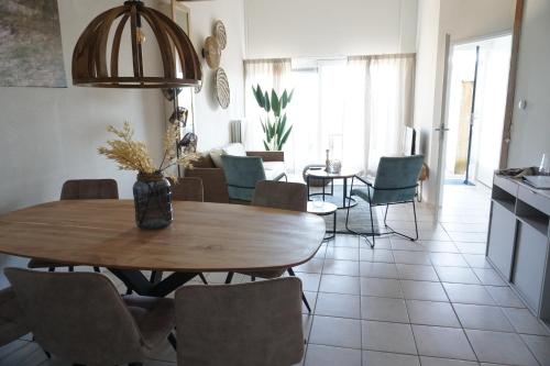 a dining room with a wooden table and chairs at Kustverhuur, Oude manege, Nieuwvliet 14-16 in Nieuwvliet