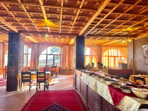 een eetkamer met een tafel met borden eten bij Dream luxury camp in Merzouga