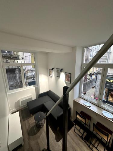 un salon avec un canapé et deux fenêtres dans l'établissement L'hypercentral - 4 Chapeaux, à Lyon