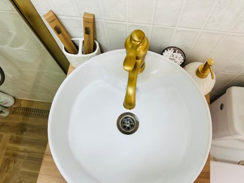 a white sink with a gold faucet on it at Andra in Drobeta-Turnu Severin
