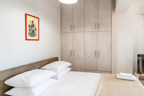 a bedroom with a bed with white pillows and a television at NT Studio in Igoumenitsa
