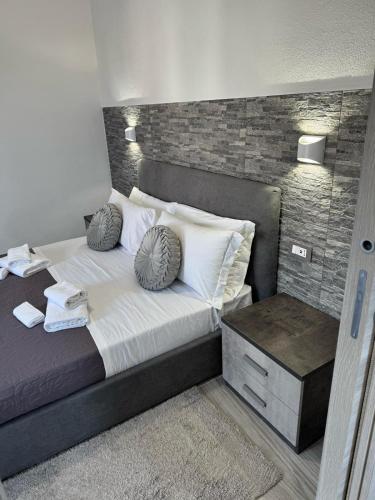 a bedroom with a large bed with a brick wall at Affittacamere Mary's Rooms in San Teodoro