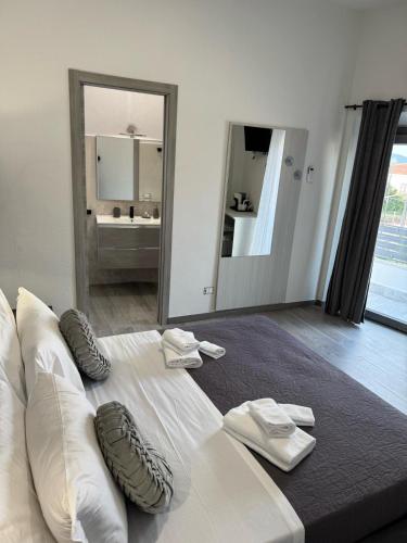 a large white bed with two pairs of shoes on it at Affittacamere Mary's Rooms in San Teodoro