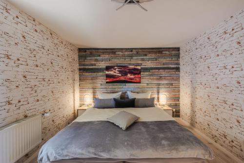 a bedroom with a large bed and a brick wall at Harzträume No4 # Parkplatz # 2 separate SZ # Smart-TV in Wernigerode