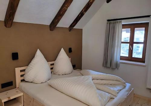 two beds with pillows on them in a room at Hoamisch in Malles Venosta