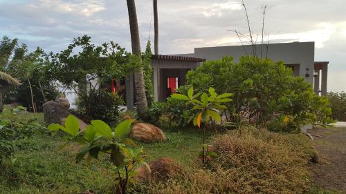a house with a red door and some plants at Rumassala Villas in Unawatuna