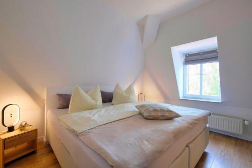 a bedroom with a white bed with a window at Harzträume No2 mit Parkplatz - Zentrum - Brockenbahn - 2 SZ in Wernigerode