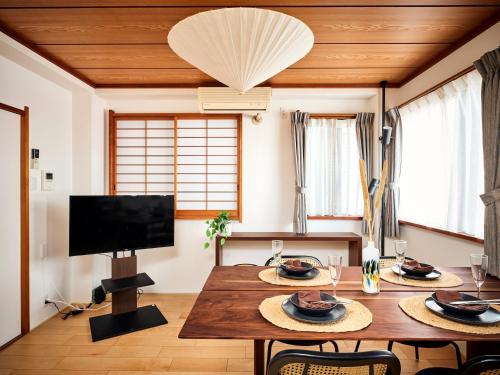 a living room with a table and a tv at Ukiyoe House 3BR 75m2 with 60m2 deck Sauna in Tokyo