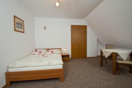 a bedroom with a bed and a table and chairs at Willa Bystra in Kościelisko