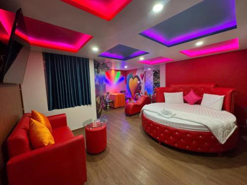 a bedroom with a bed and red chairs and purple lights at Khách Sạn Lộc Thọ in Ho Chi Minh City