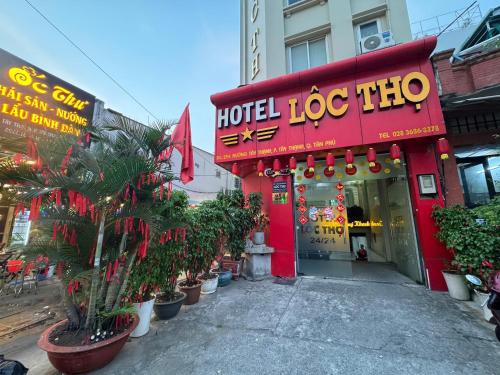 a hotelocatechinchinatownatown with a red building with plants in front at Khách Sạn Lộc Thọ in Ho Chi Minh City
