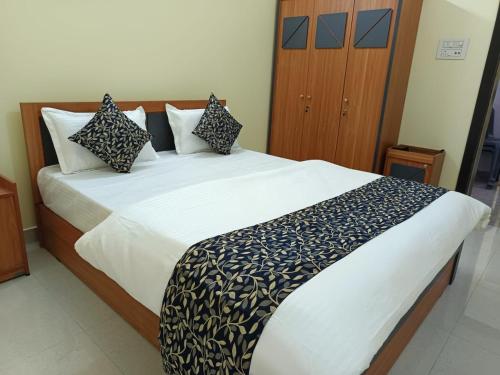 a bedroom with a large bed with black and white pillows at Hotel Silver Park and Restaurant in Bilāspur