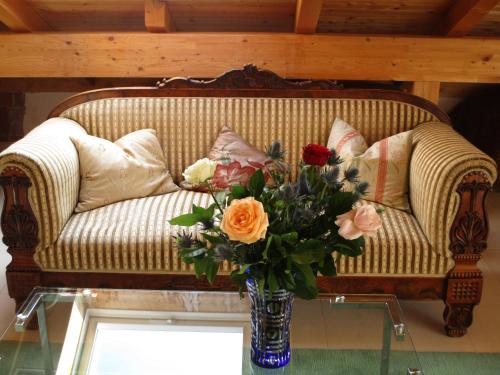 a vase of flowers on a table in front of a couch at Chalet Valley in Valley