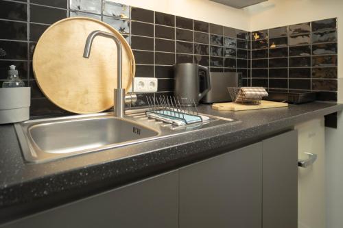 a kitchen counter with a sink and a mirror at Studios am Kniepertor in der Altstadt in Stralsund