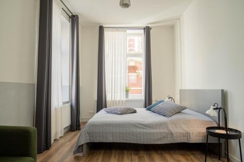 a bedroom with a bed and a large window at Studios am Kniepertor in der Altstadt in Stralsund
