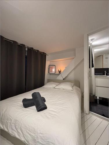 - une chambre avec un lit blanc et une serviette noire dans l'établissement Le Cosy Terreaux, à Lyon