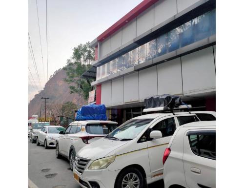 a row of cars parked in front of a building at Jai Badri Vishal Hotel and Restaurant, Pipalkoti in Pīpalkoti