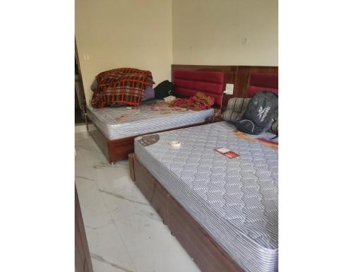 two beds sitting in a room with at Jai Badri Vishal Hotel and Restaurant, Pipalkoti in Pīpalkoti