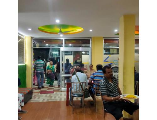 a group of people sitting in a restaurant at Jai Badri Vishal Hotel and Restaurant, Pipalkoti in Pīpalkoti