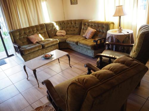 a living room with a couch and a coffee table at Smirna Guesthouse in Vryburg