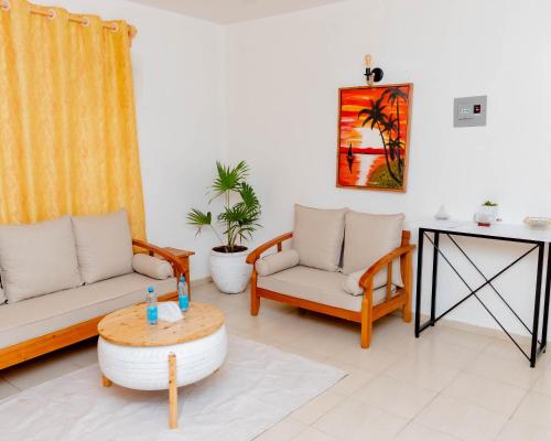 a living room with two couches and a table at Pinebreeze Holiday Resort in Nyali
